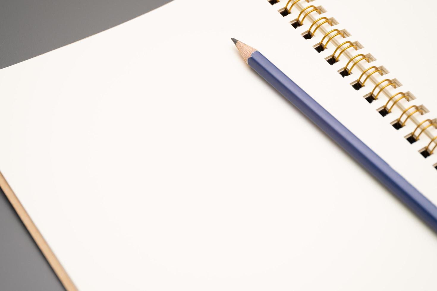 cuaderno con un lápiz. cuaderno espiral abierto en blanco con lápiz foto