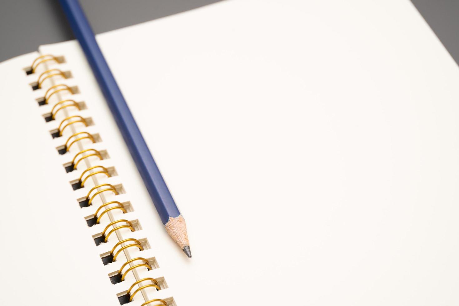 cuaderno con un lápiz. cuaderno espiral abierto en blanco con lápiz foto
