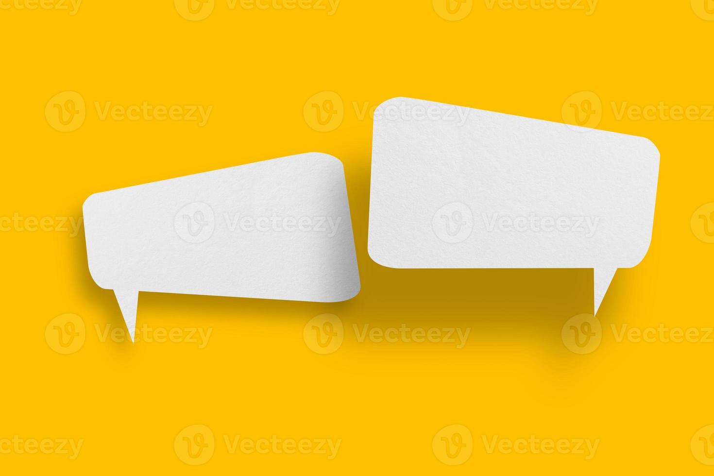 White paper in speech bubble shape set against yellow background. photo