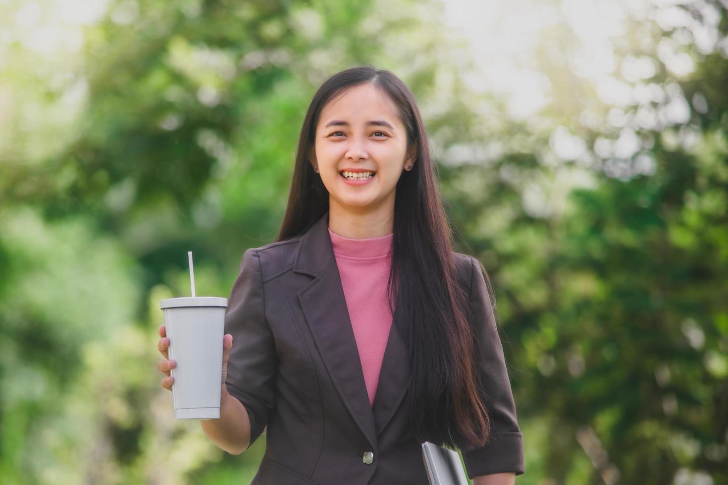 business woman Standing drink coffee in the park beside the town photo