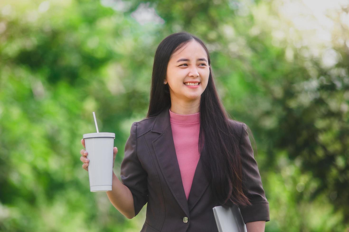 business woman Standing drink coffee in the park beside the town photo