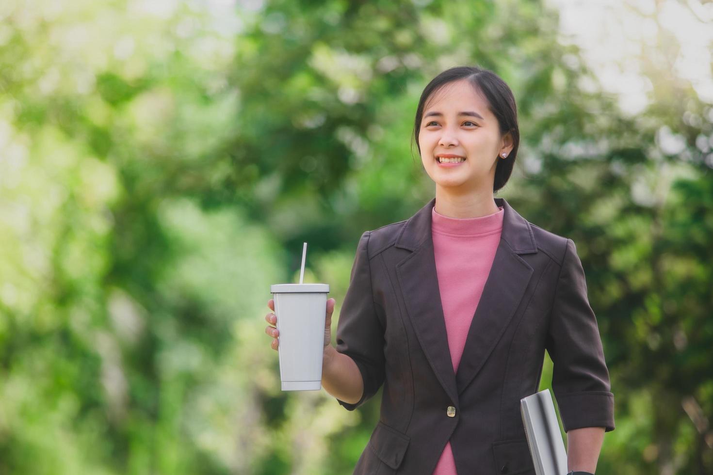 business woman Standing drink coffee in the park beside the town photo