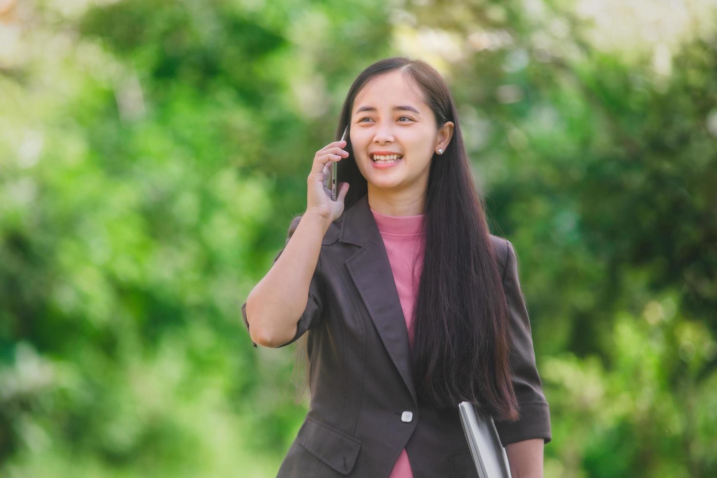 business woman Standing on the phone in the park beside the town photo