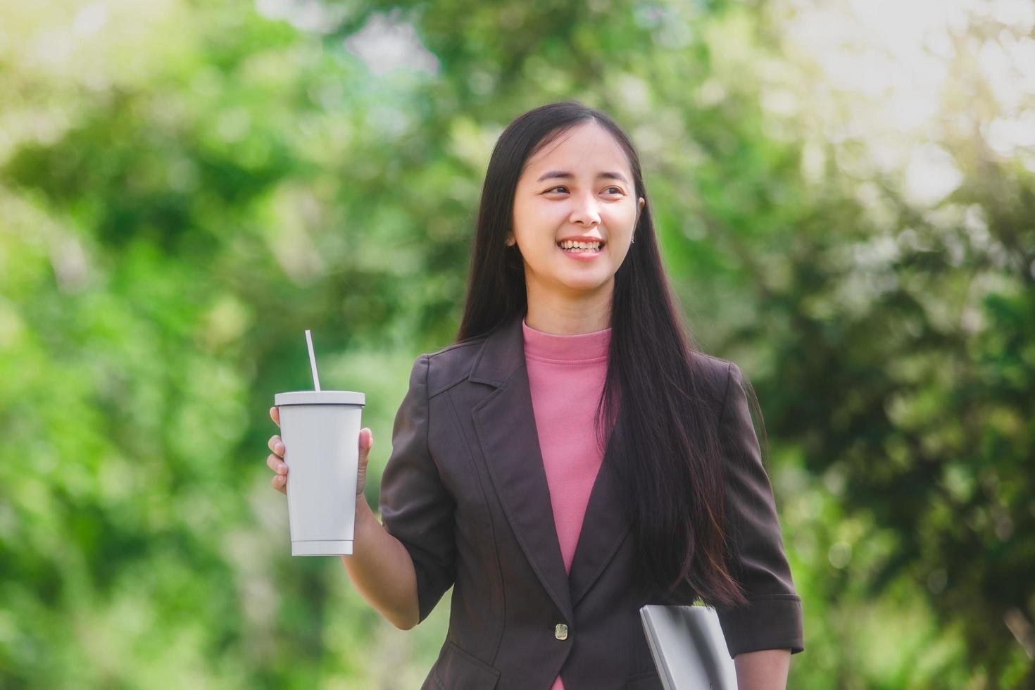 business woman Standing drink coffee in the park beside the town photo