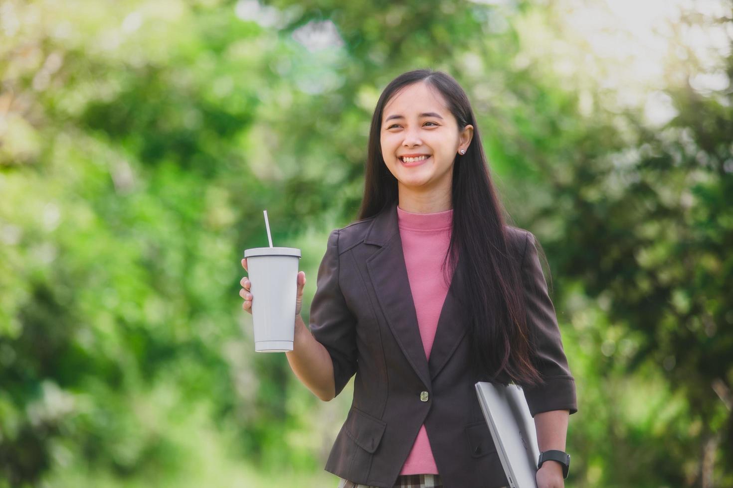 business woman Standing drink coffee in the park beside the town photo