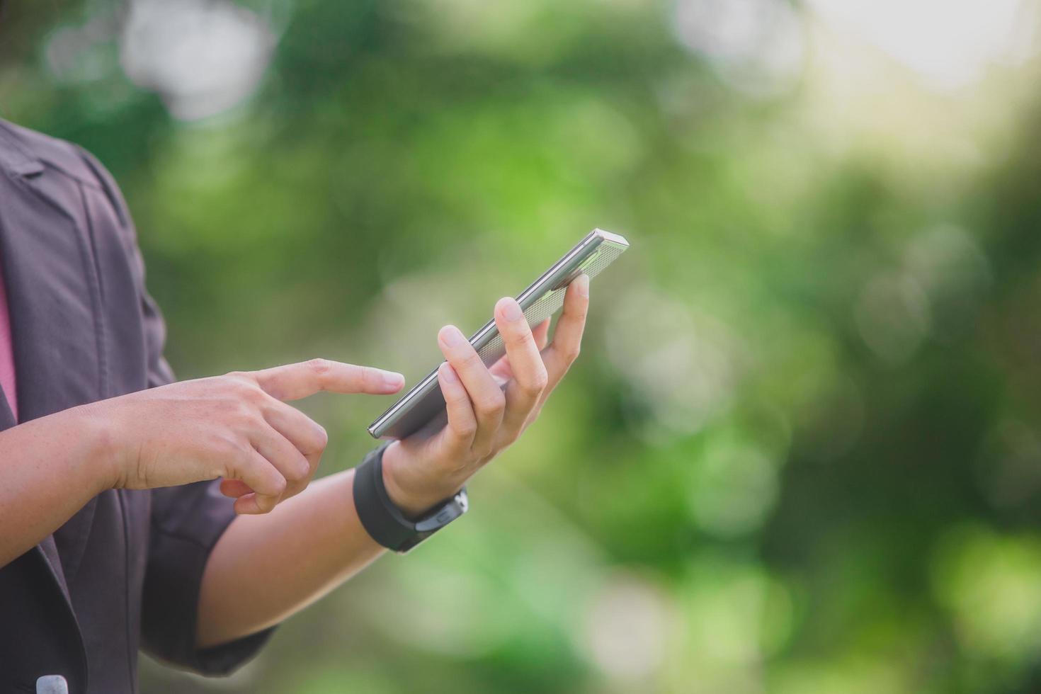 business woman Standing on the phone in the park beside the town photo