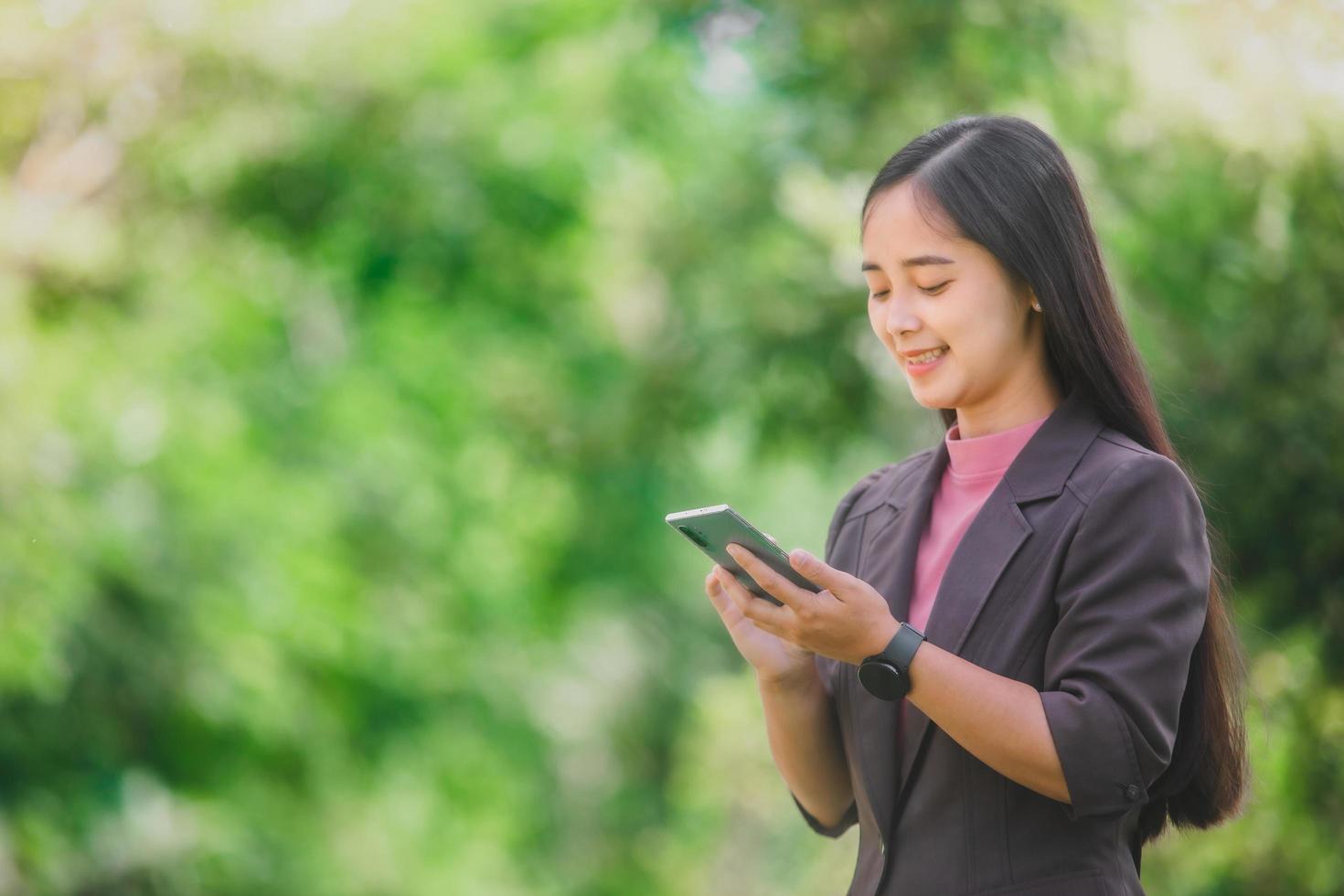 business woman Standing on the phone in the park beside the town photo