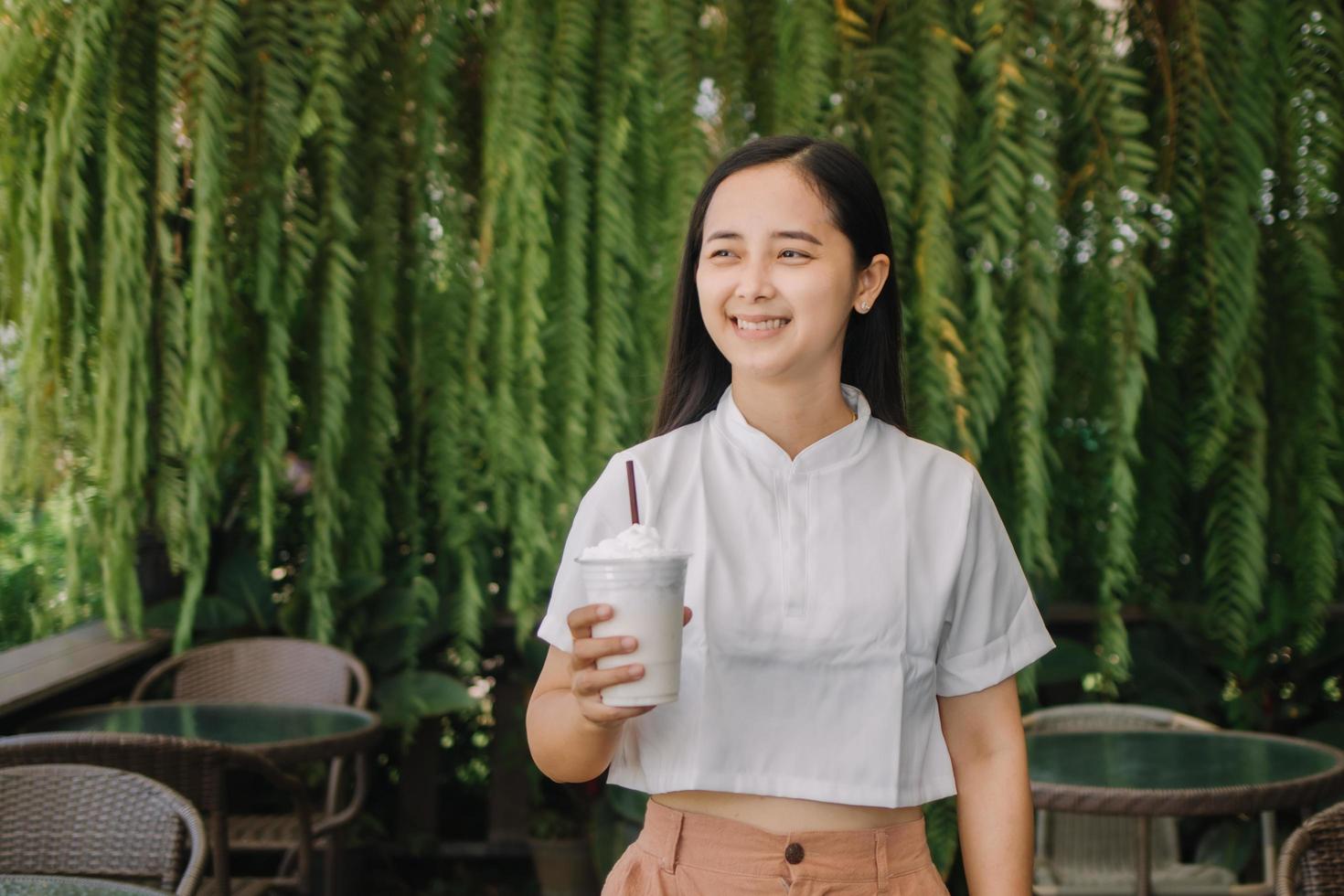 A happy businesswoman in a suit standing in a park and having a phone conversation. She is holding takeaway coffee. A businesswoman in a park on a break photo