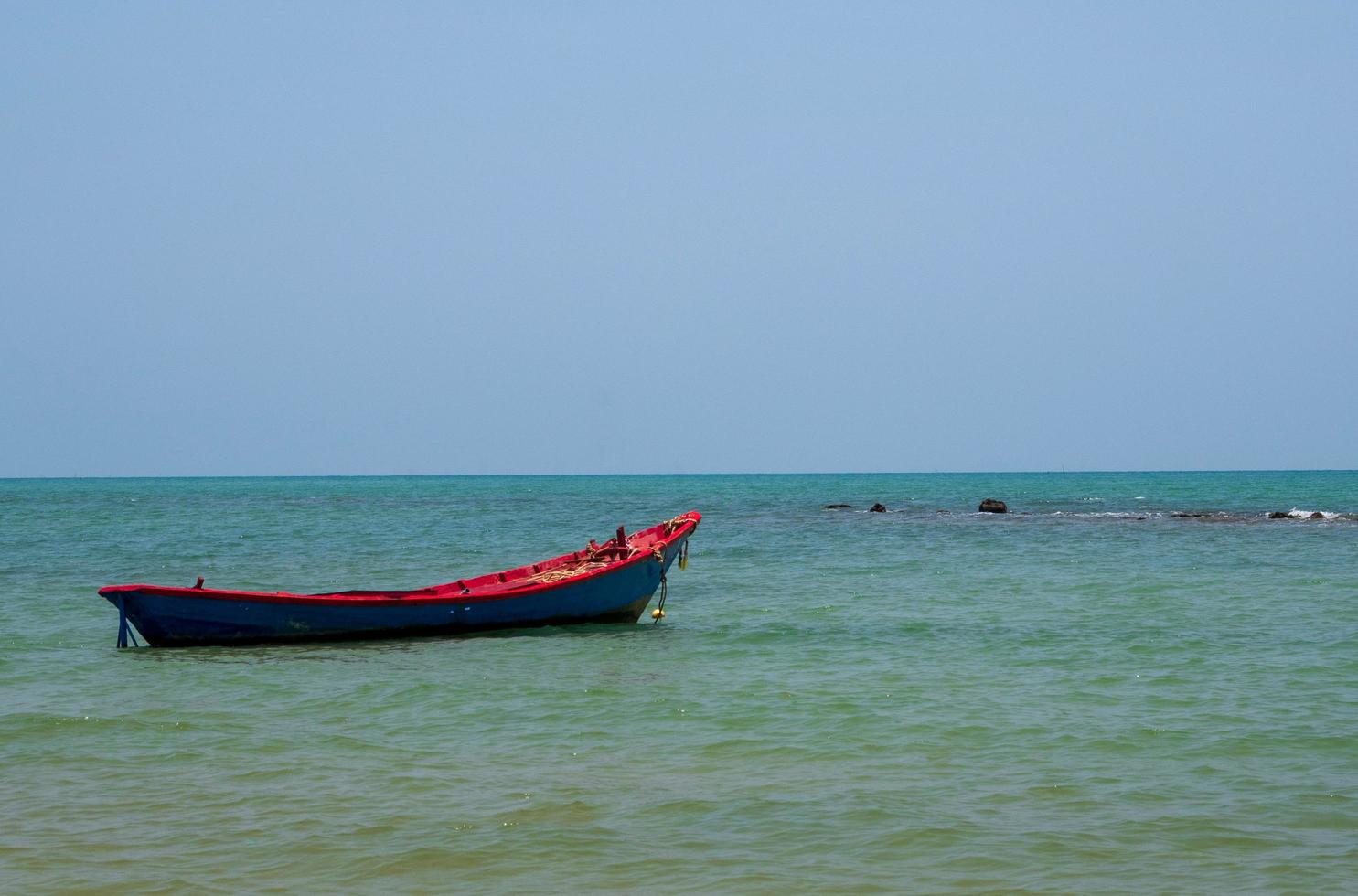 paisaje mirada vista pequeño barco de pesca de madera antiguo estacionado costa el mar. después de la pesca de los pescadores en el pequeño pueblo es pequeña pesca local. cielo azul, nubes blancas, clima despejado, playa phala, rayong foto