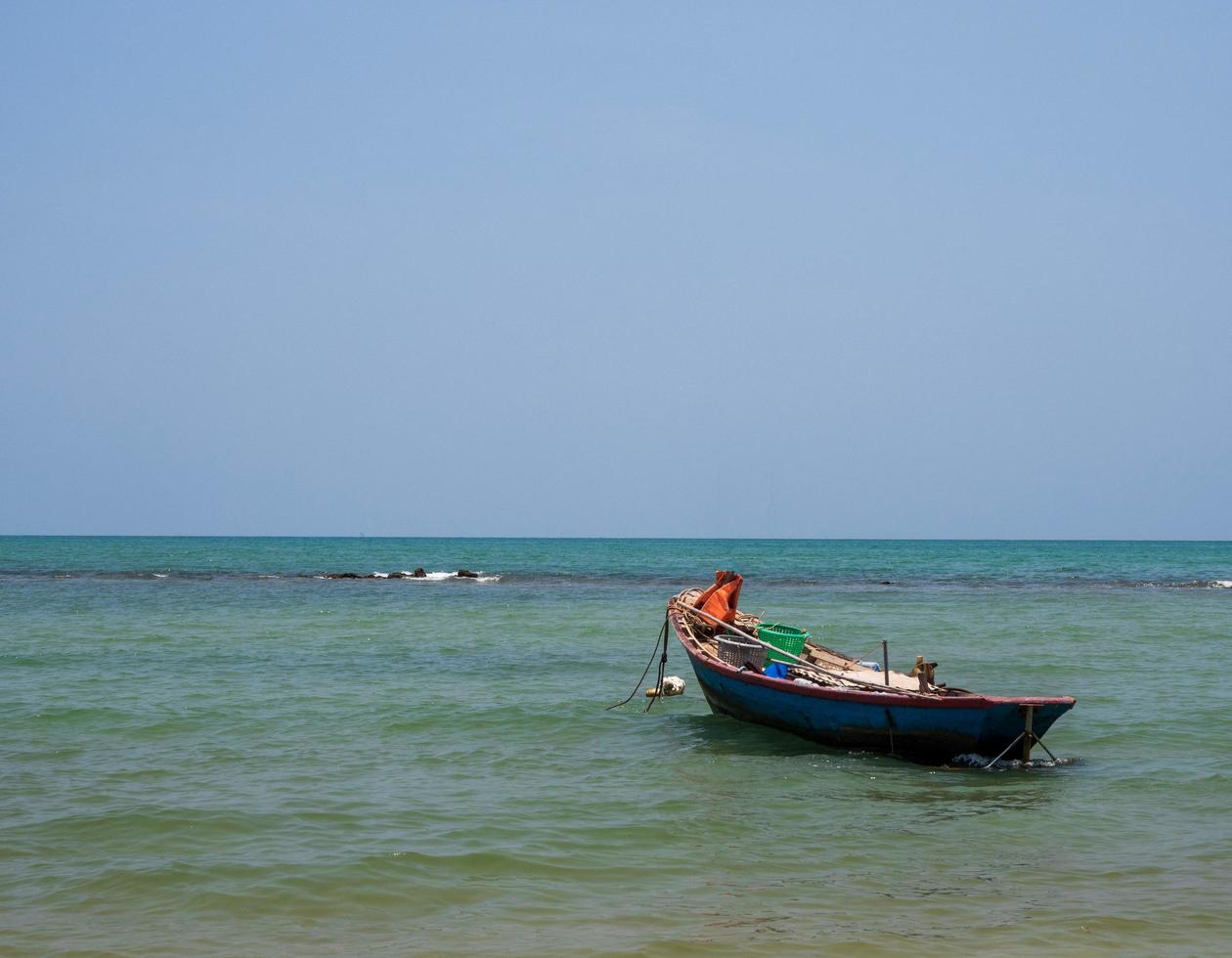 landscape look view Small fishing boat wooden old parked coast the sea. after fishing of fishermen in small village It small local fishery. Blue sky, white clouds, clear weather, Phala Beach, Rayong photo