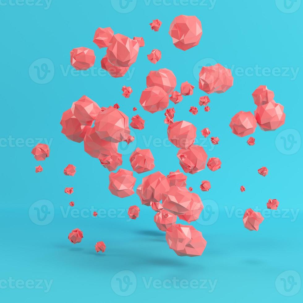 Red flying low poly spheres on bright blue background in pastel colors photo