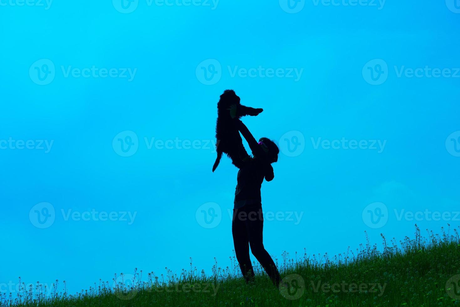 Silhouette of young woman with her dog photo