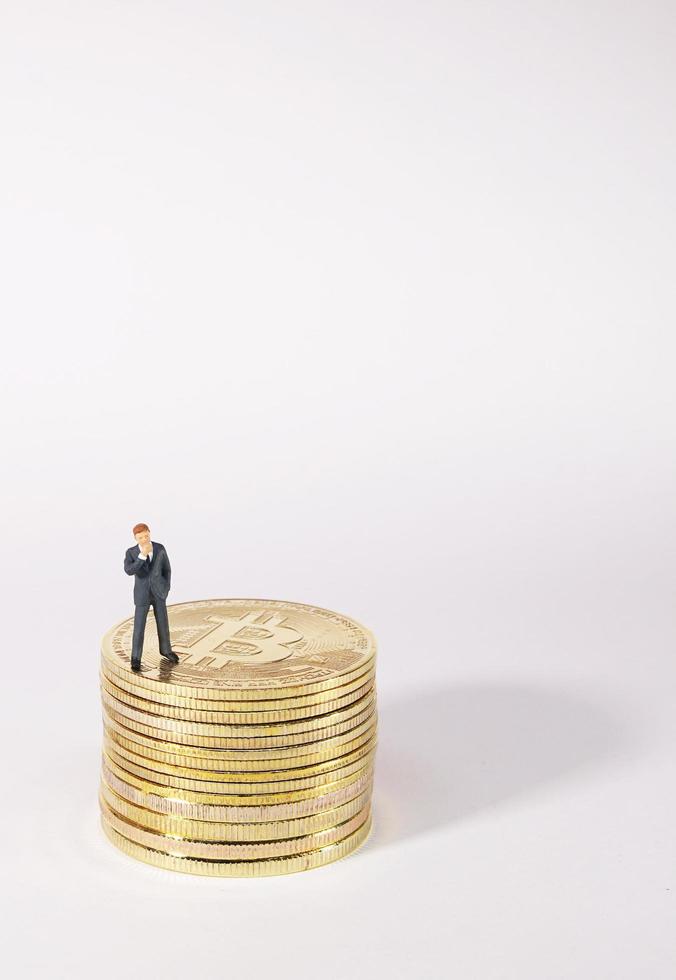 Business man figure standing on bitcoin. Bitcoin mining concept. photo