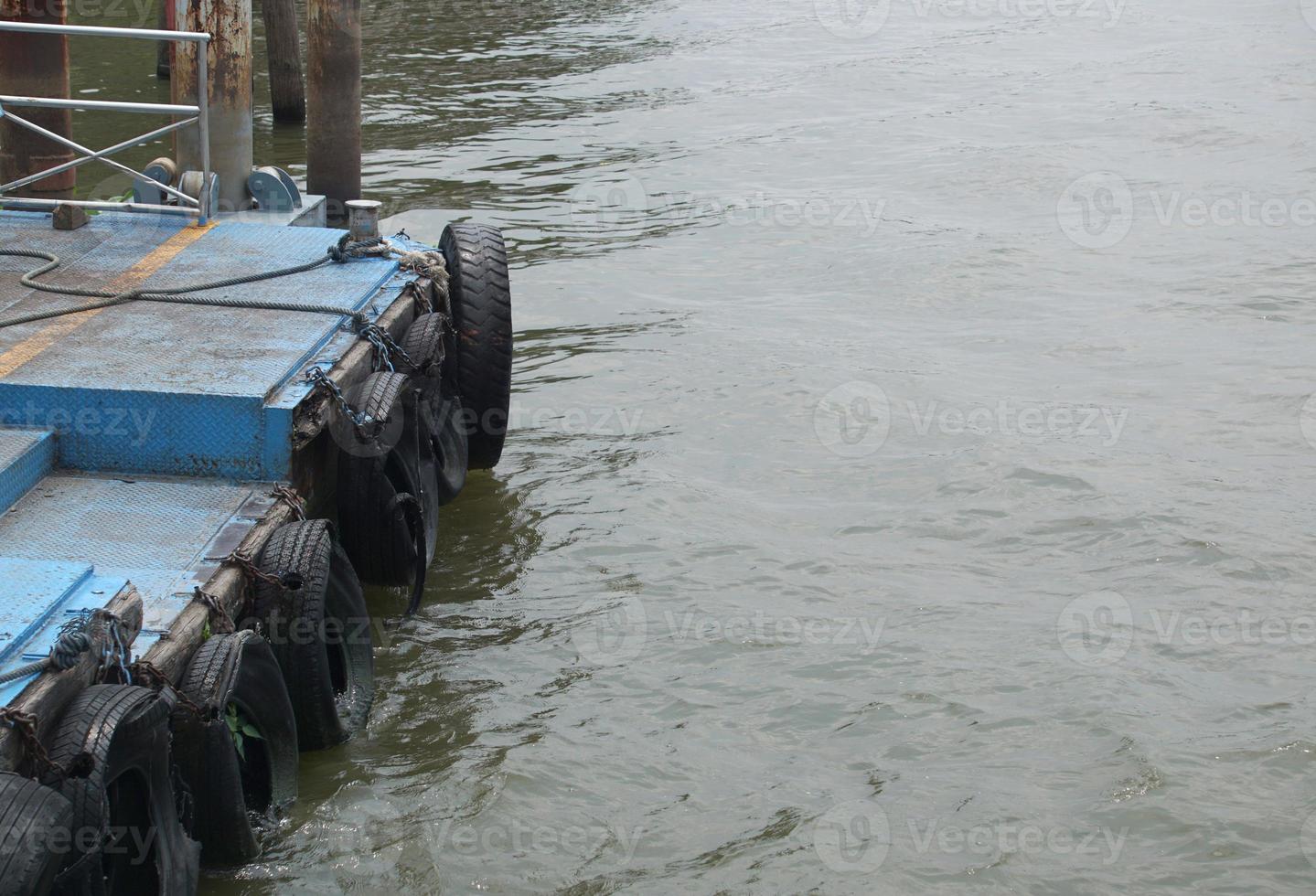 los neumáticos están unidos a cadenas para amortiguar el borde del muelle. foto