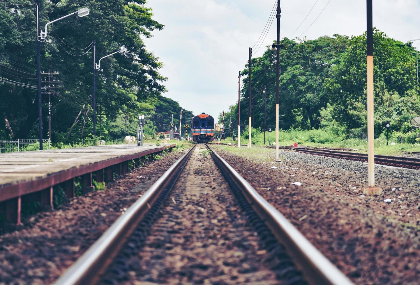 railroad tracks train leading from train station railway in countryside vintage old film style photo