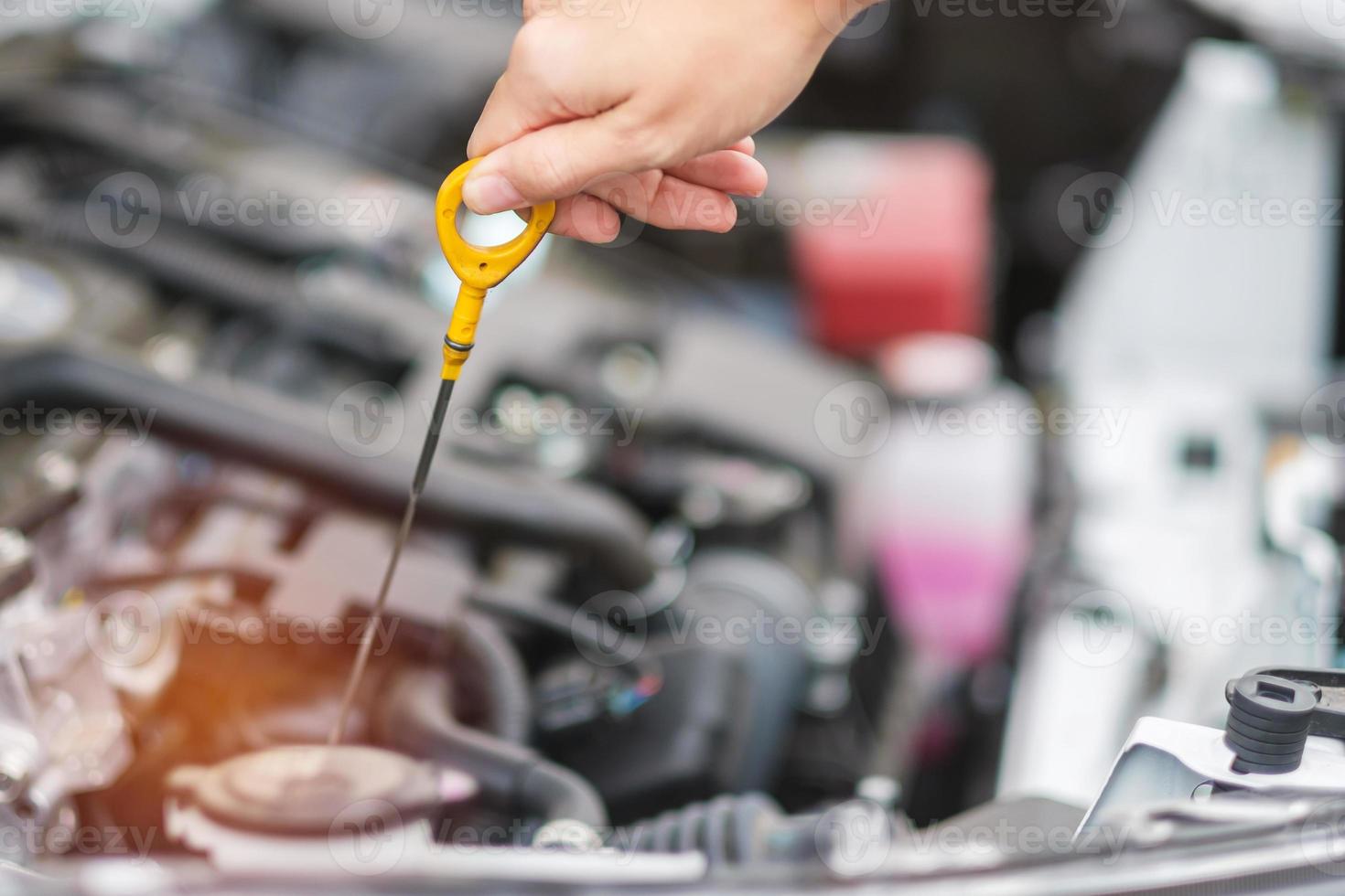 woman hand  check oil level in car engine. Self Maintenance, repair and problem concept photo