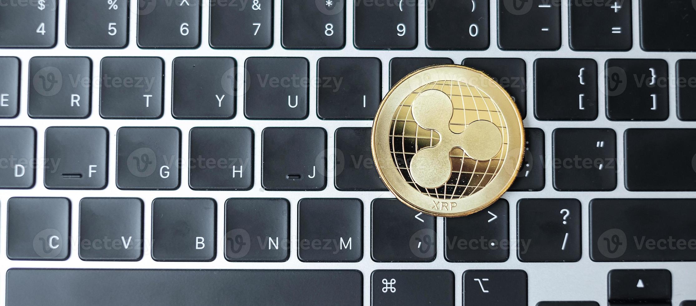 criptomoneda dorada en la computadora portátil con teclado, moneda ondulada. crypto es dinero digital dentro de la red blockchain foto