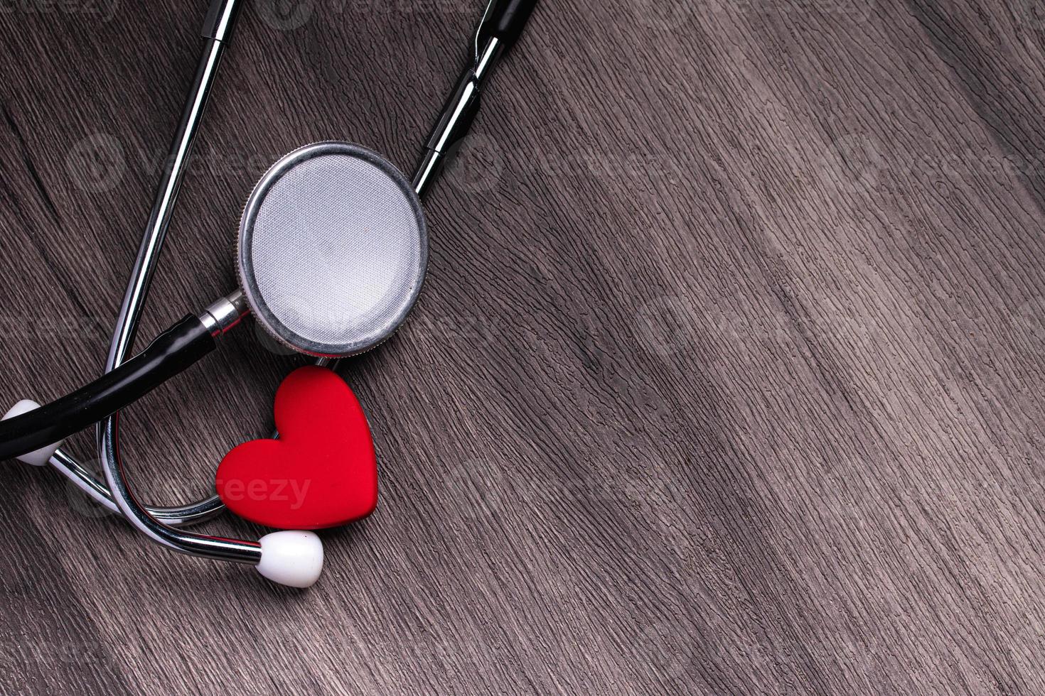 Stethoscope with red heart on gray background. Heart health care concept. photo