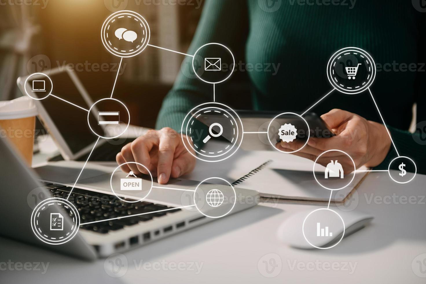 Businesswoman using mobile phone and laptop computer on white desk with VR chart and graph photo