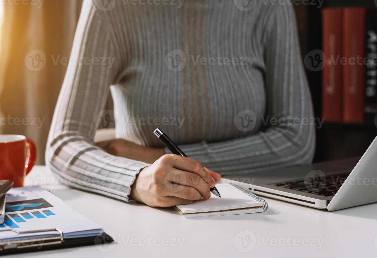 businessman hand working with new modern computer and writing on the notepad strategy diagram as concept morning light photo