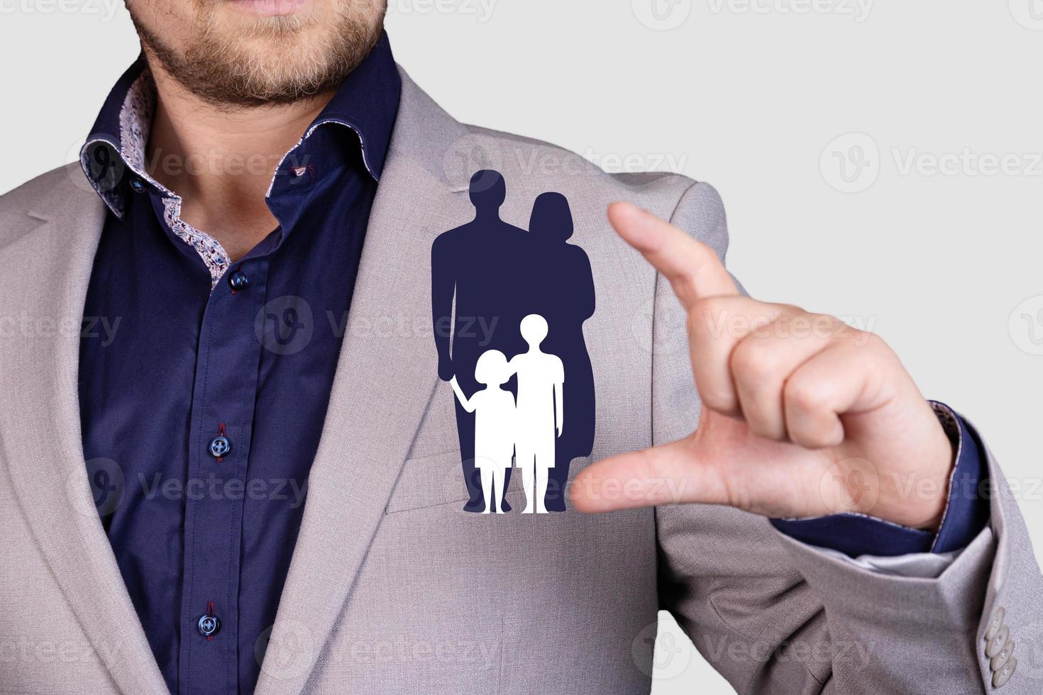 The concept of an insurance company to protect and support its client, family icon. Protected by the hands of a businessman photo