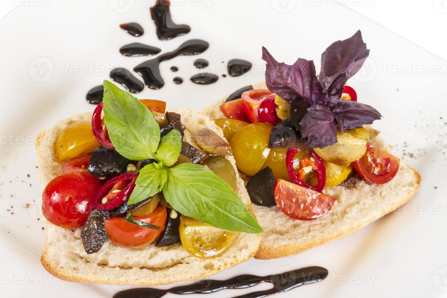 juicy tomatoes on fresh bread, pesto as topping photo