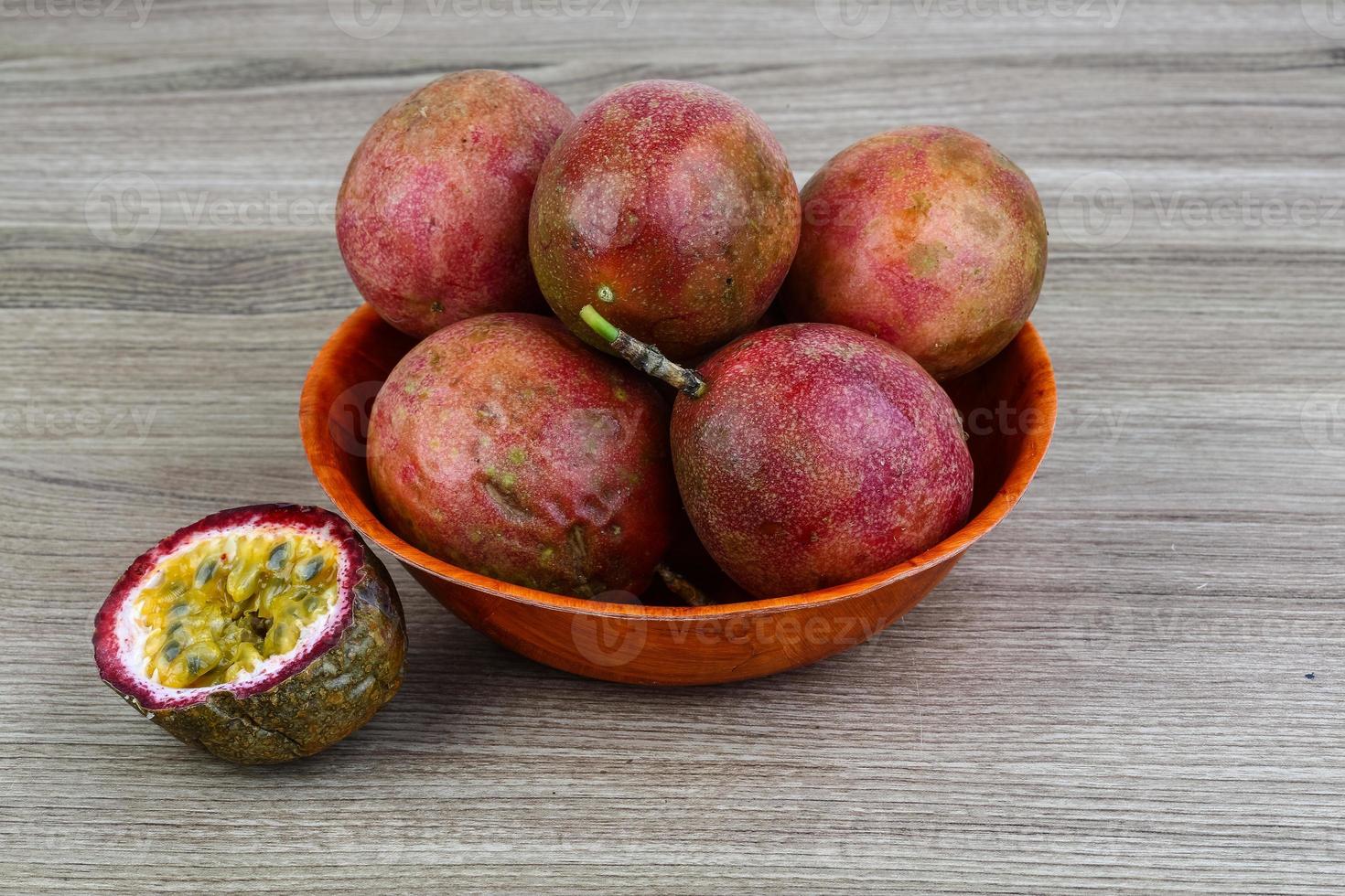 Fresh tropical fruit - Maracuja in a bowl on wooden background photo