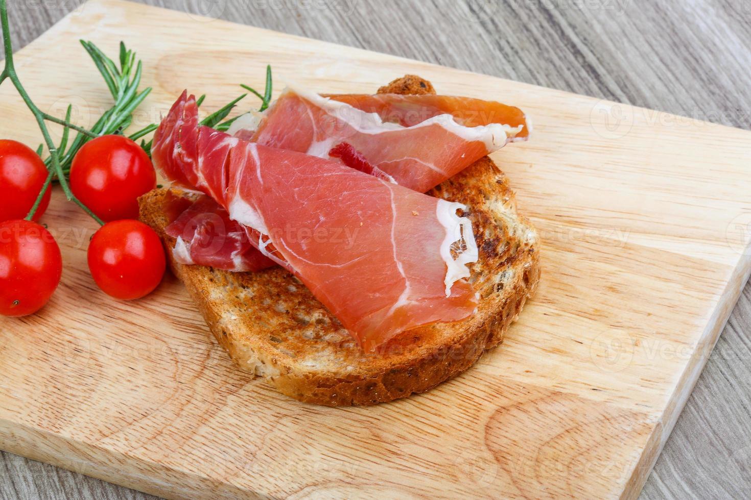 Jamon tapas on wooden plate and wooden background photo