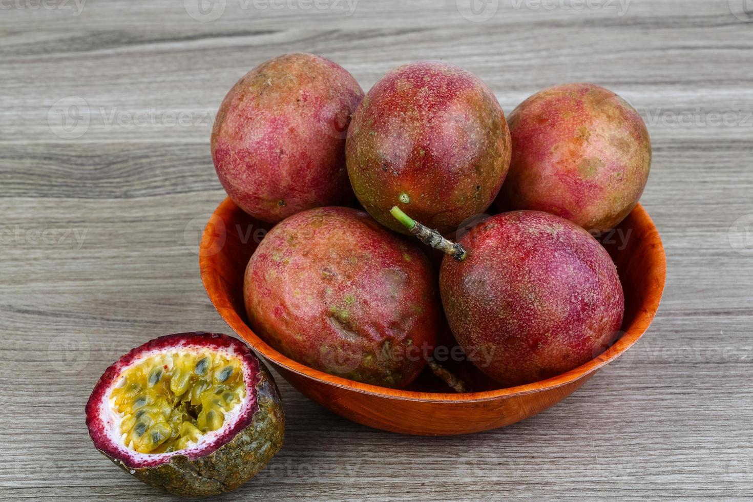 Fresh tropical fruit - Maracuja in a bowl on wooden background photo