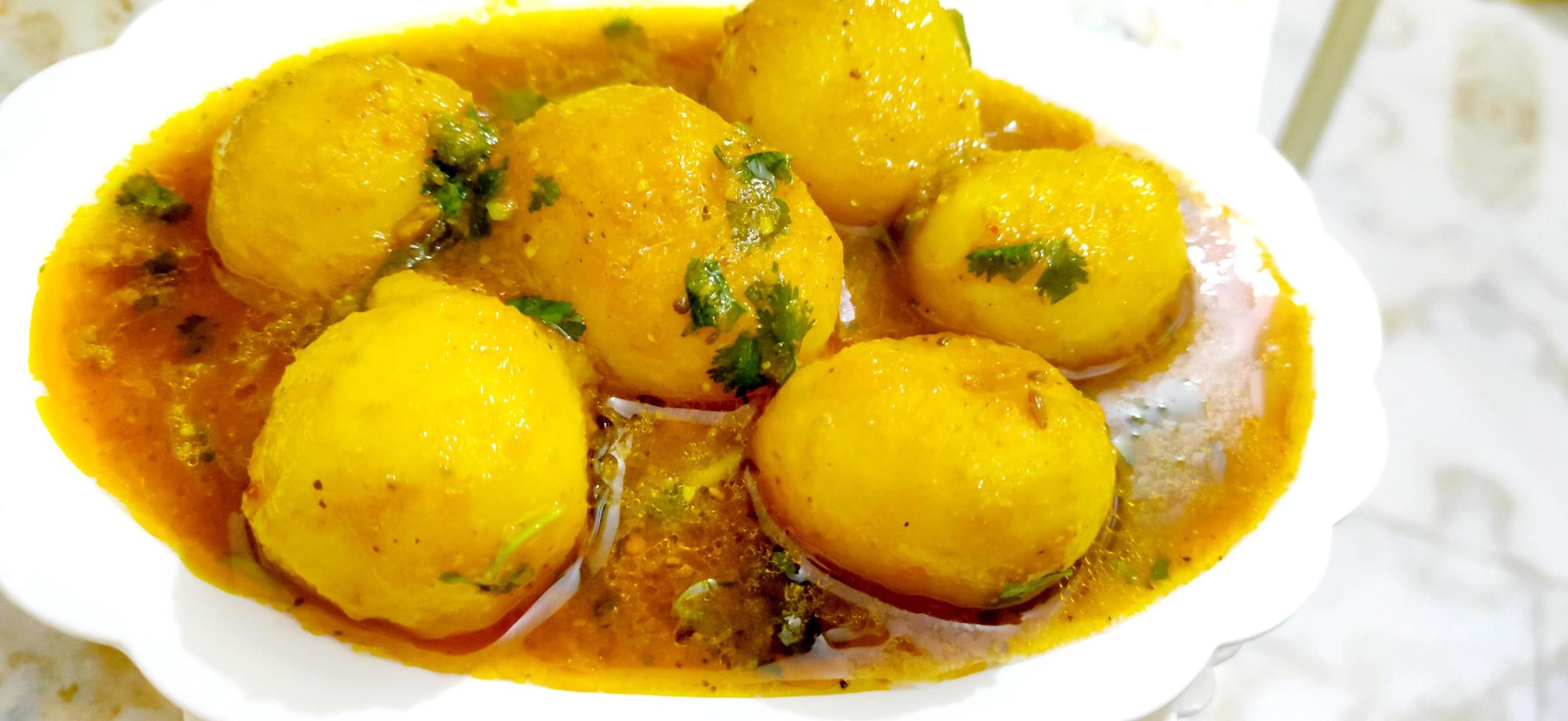 Indian Dum aloo curry using fried potatoes and spices, served in a bowl. selective focus photo