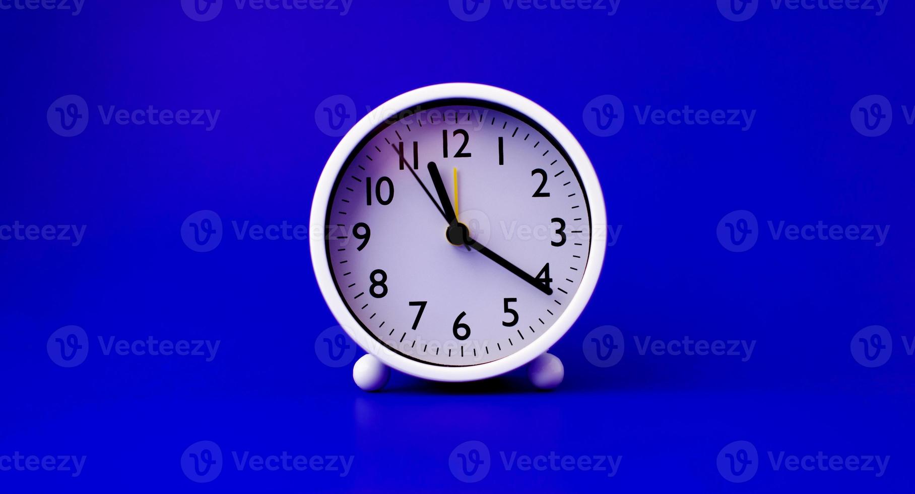 white clock placed on a blue background The concept of time and the importance of time photo