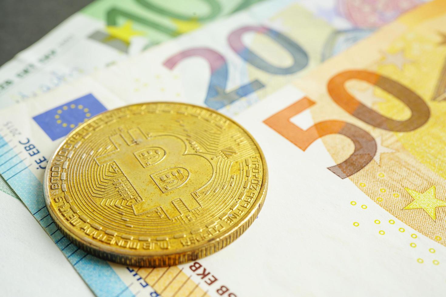 bitcoin dorado en billetes en euros dinero para negocios y comercio, moneda digital, criptomoneda virtual. foto