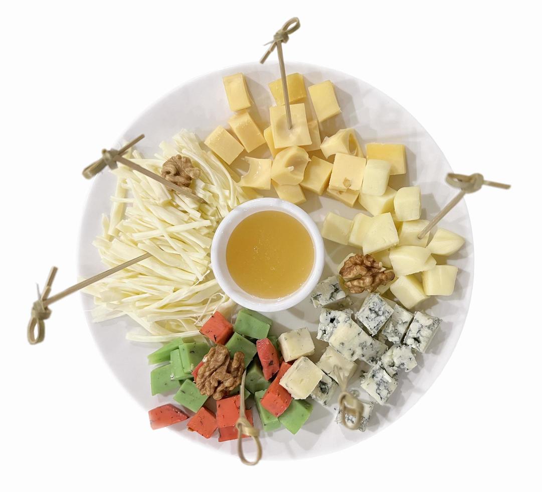 cheese plate flatley. cheese slices assortment. different kind of cheese, honey. table setting, snacks. healthy food photo