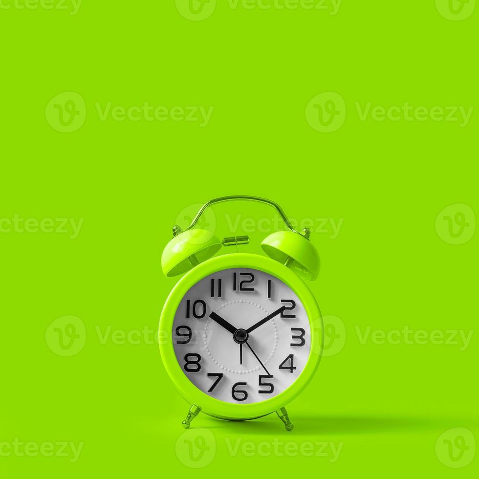 Green alarm clock on green background. photo