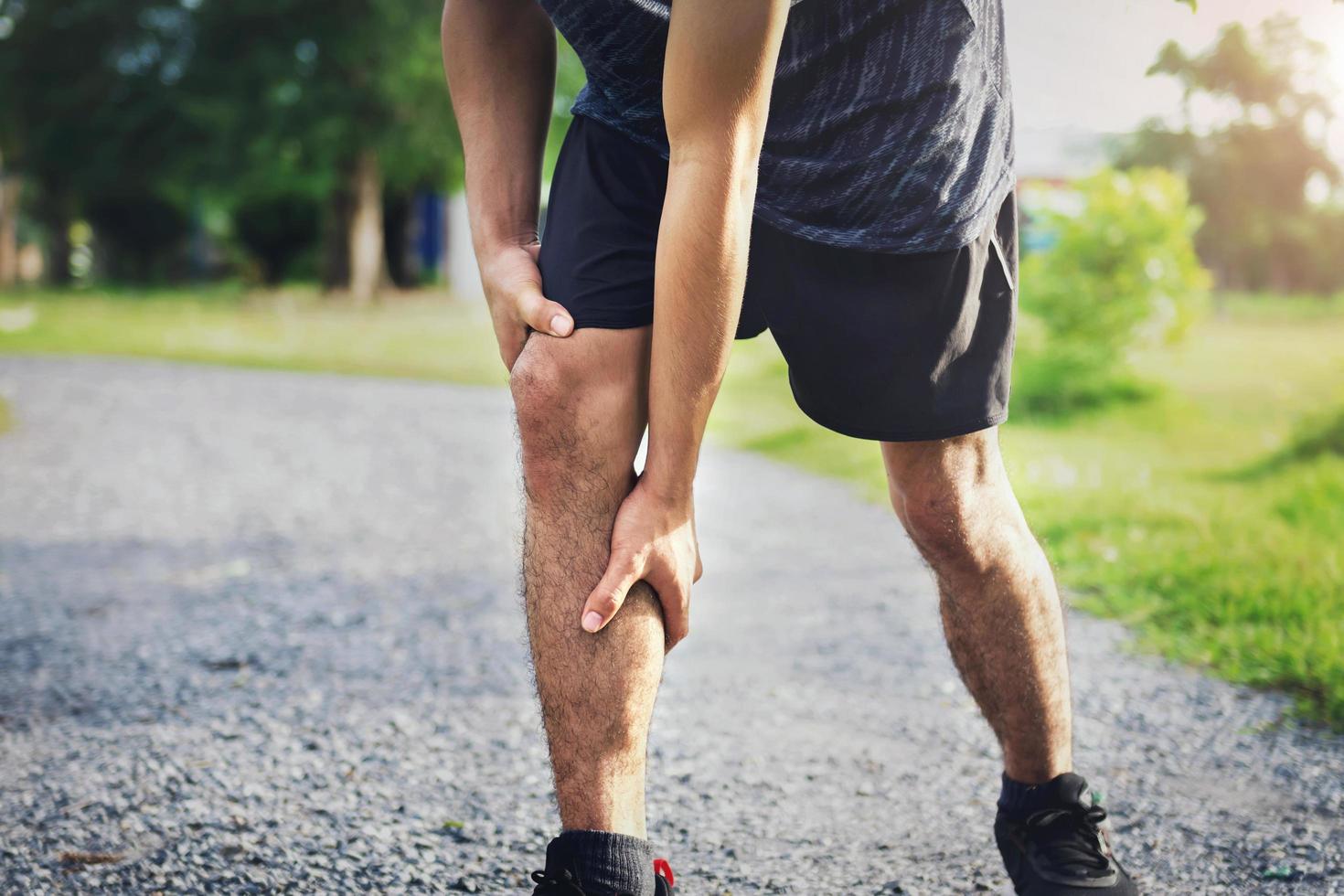 los hombres heridos por el ejercicio usan sus manos para sostener sus rodillas foto