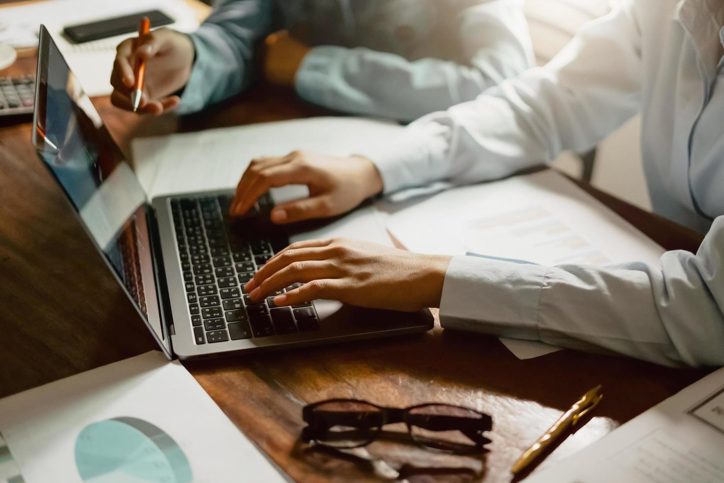 mujer de negocios usando la mano de la computadora portátil escribiendo en el teclado para reunirse con el equipo en la oficina. concepto de finanzas y contabilidad foto