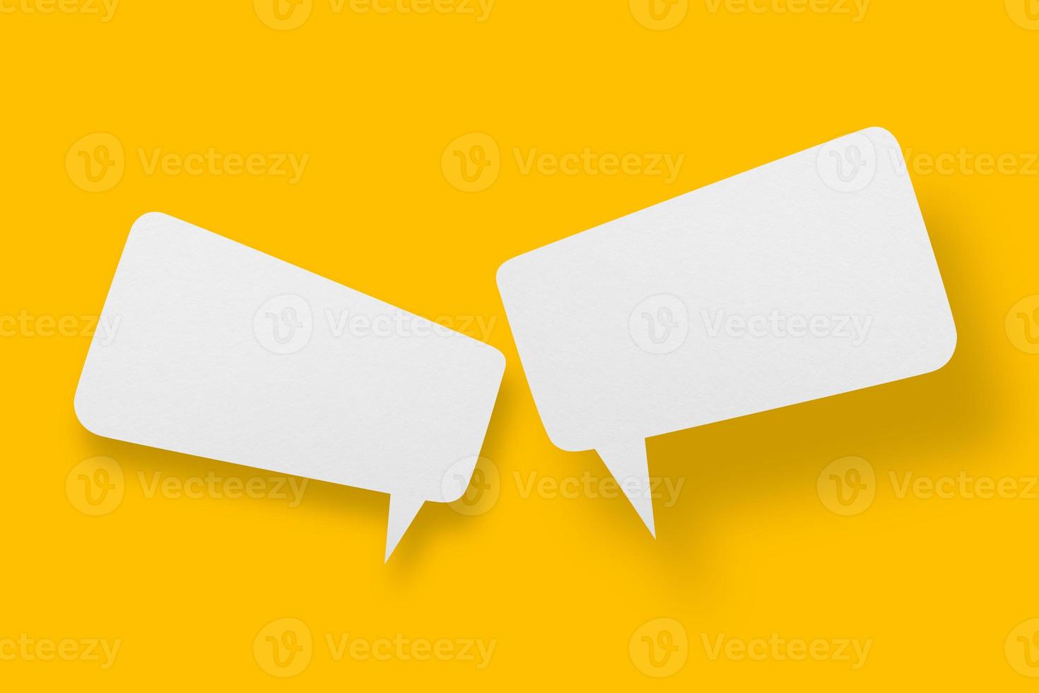 White paper in speech bubble shape set against yellow background. photo