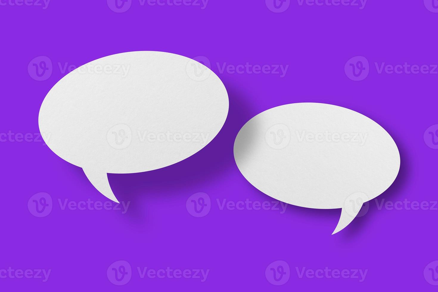 White paper in the shape of speech bubbles against a purple background. communication bubbles photo