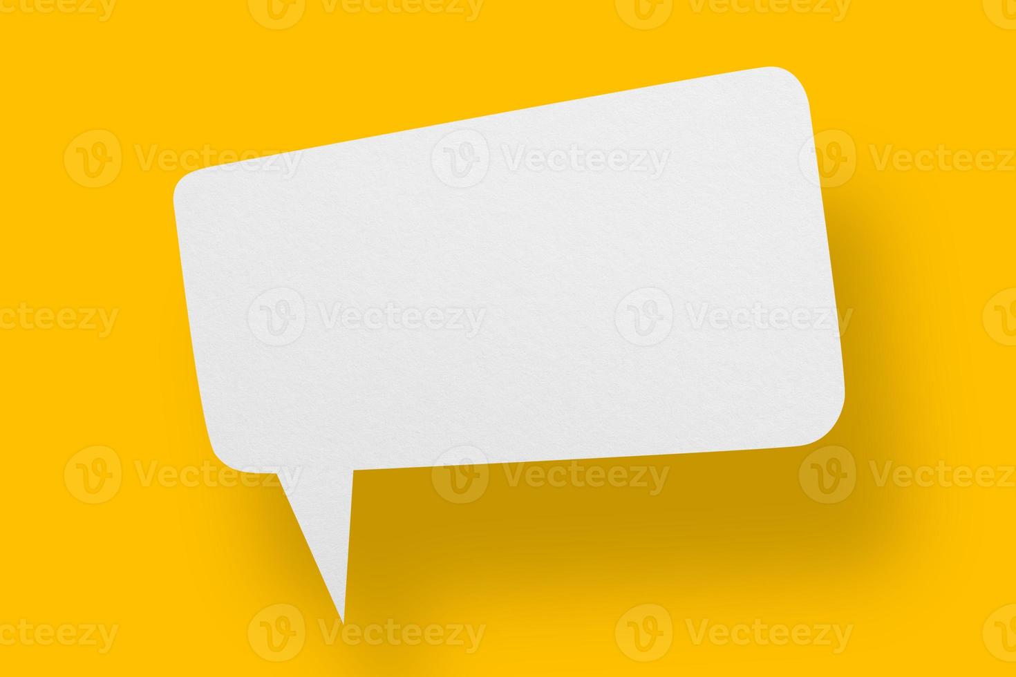 White paper in speech bubble shape set against yellow background. photo