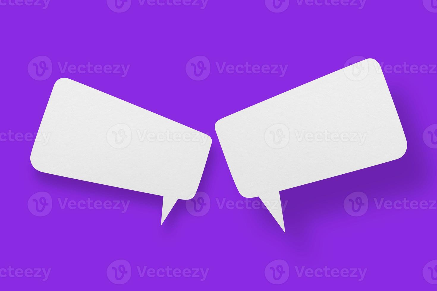 White paper in the shape of speech bubbles against a purple background. Communication bubbles. photo
