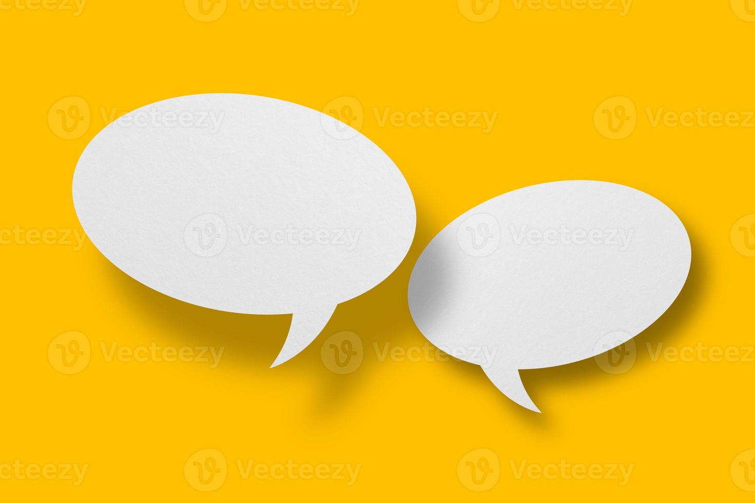 White paper in speech bubble shape set against yellow background. photo