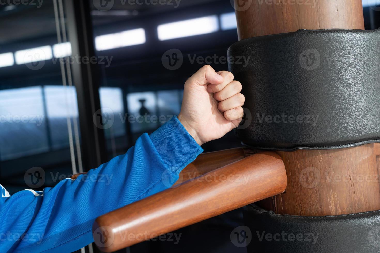 The athlete shows techniques Wing-Chun Kung-Fu wooden dummy. Wing Chun Kung Fu Self defense. Training in the art of self-defense photo