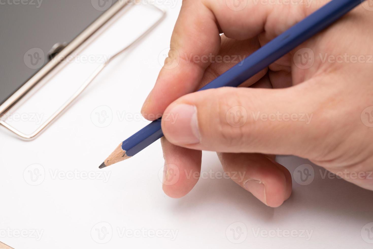 hand writing on clipboard. Stationery. write a note on empty blank with a pencil photo