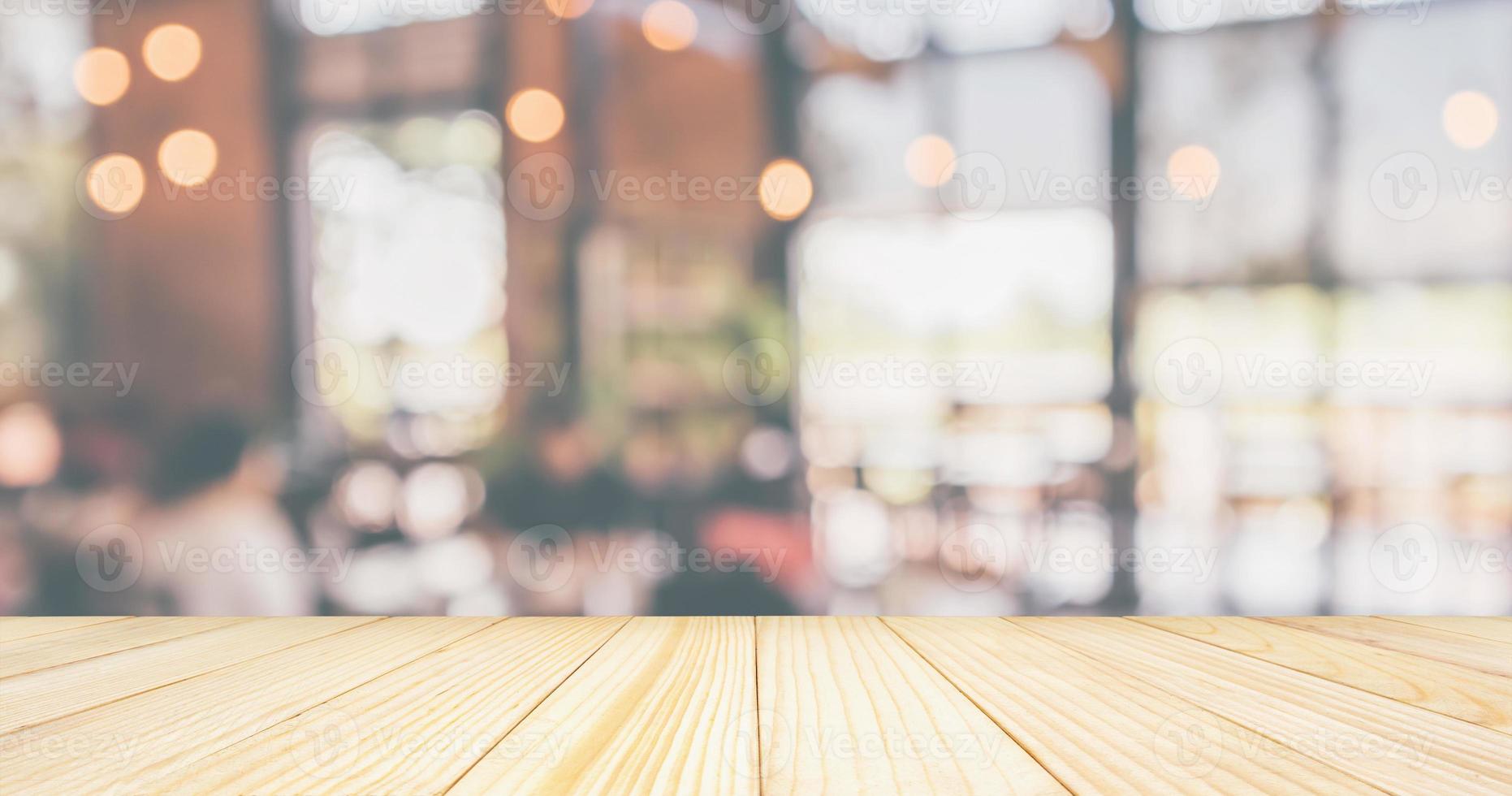 Empty Wood table top with Restaurant cafe or coffee shop interior with customer blur abstract vintage style bokeh light for montage product display background photo