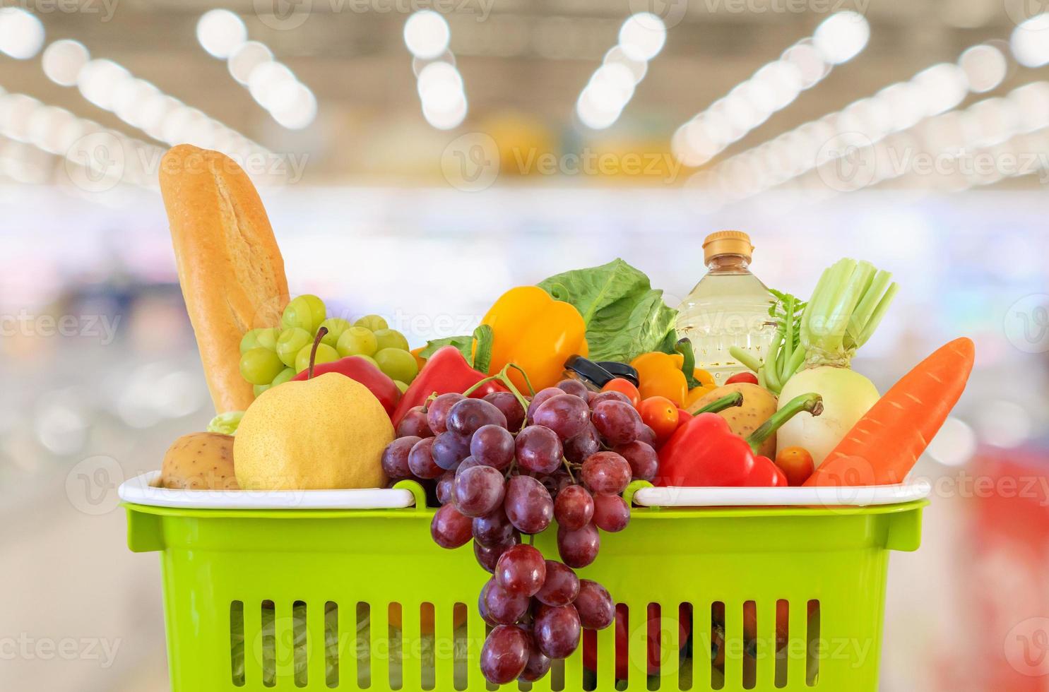 cesta de la compra llena de frutas y verduras con supermercado tienda de comestibles fondo desenfocado borroso con luz bokeh foto