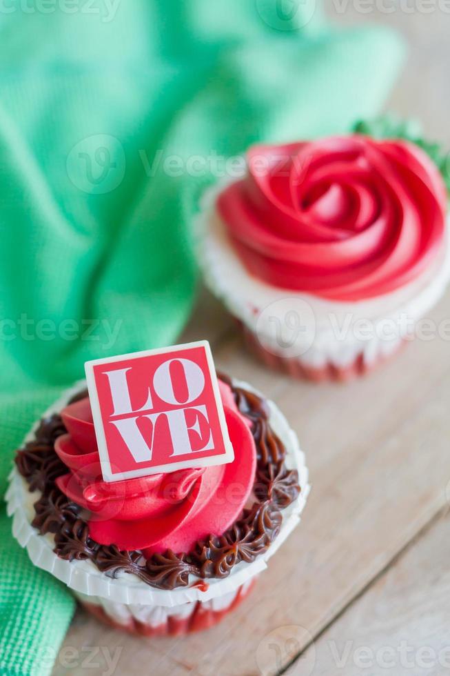 red rose cupcakes on wooden table photo