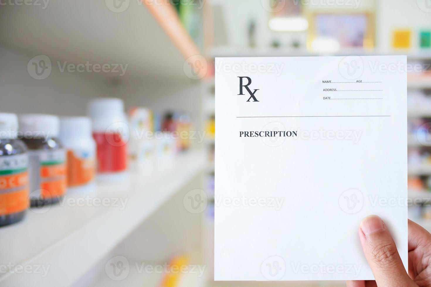 mano del farmacéutico con papel de prescripción en la farmacia foto