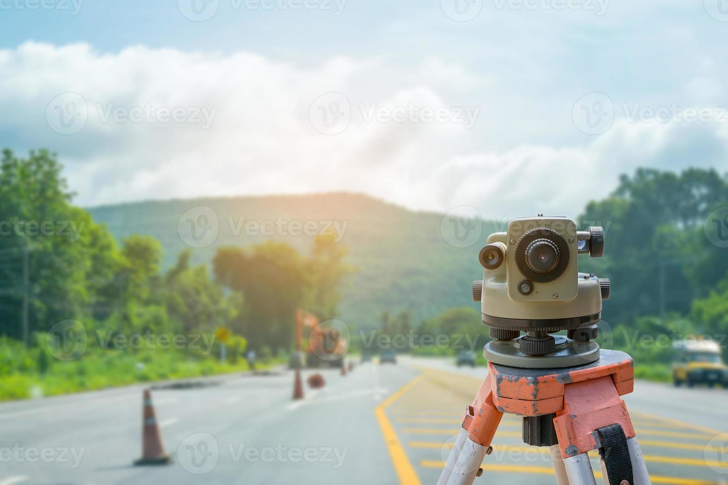 Tacómetro o teodolito del equipo topógrafo con fondo de obra de construcción de carreteras foto