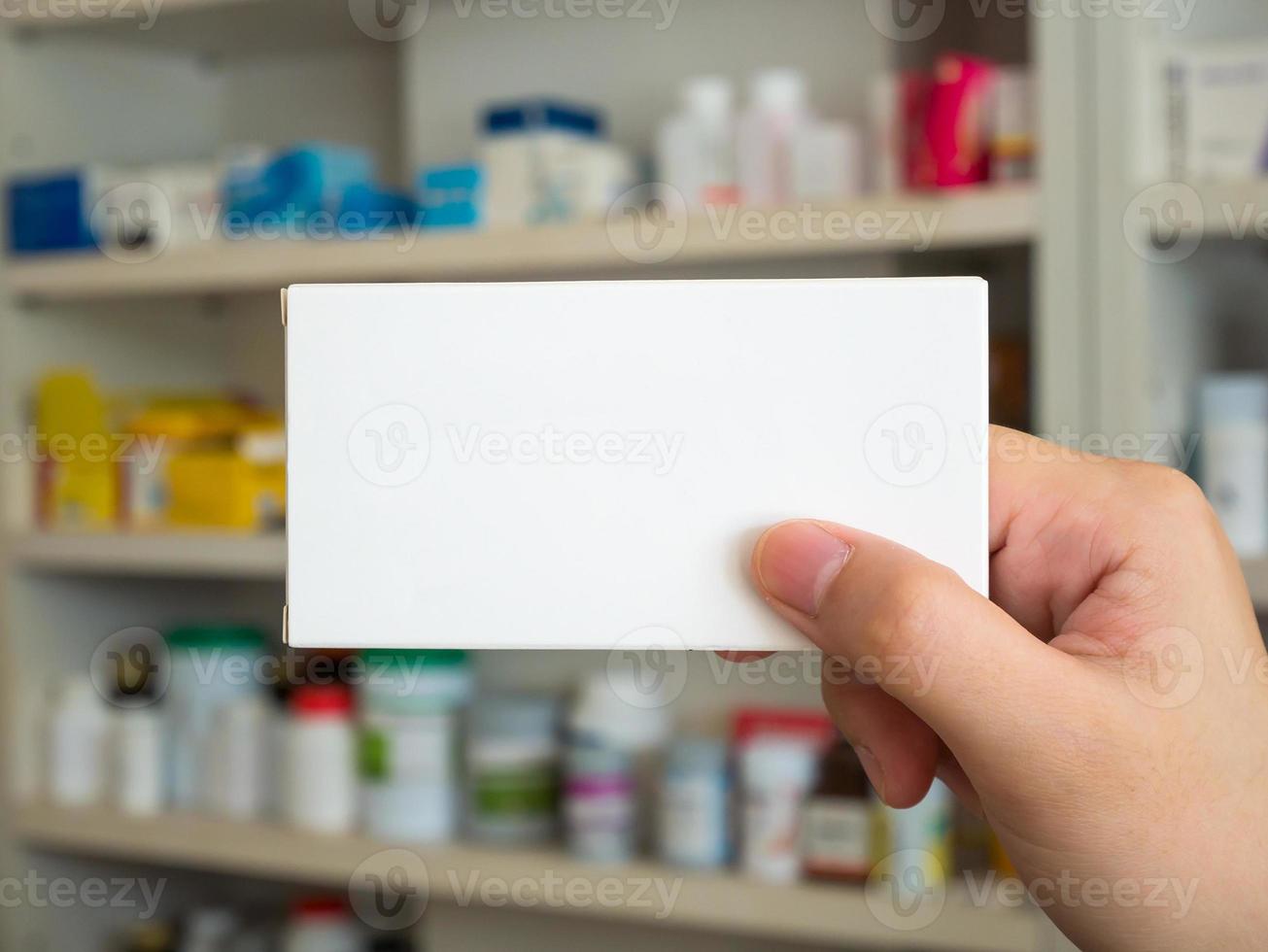 Close up pharmacist hand hold medicine box package photo