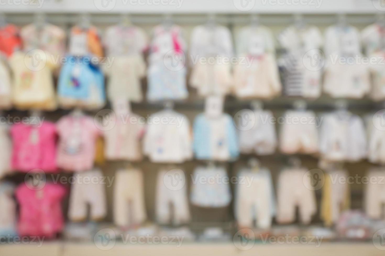Abstract blur newborn baby clothes hanging on shelf at children clothing  store for background photo